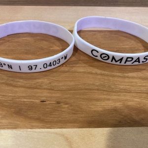 2 CØMPASS silicone wristbands.